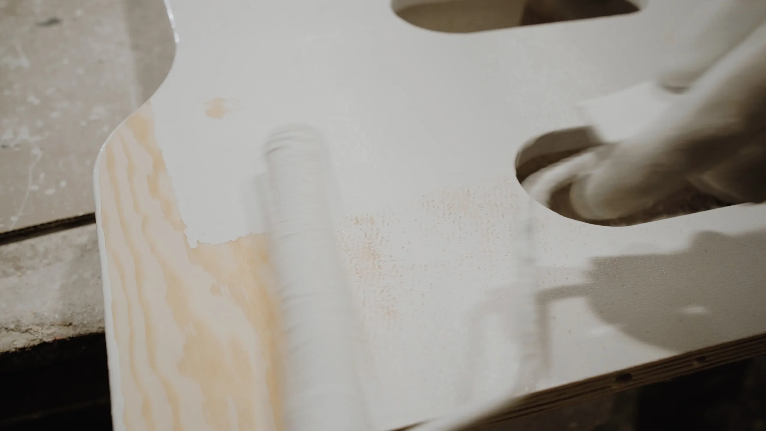 Application à la main d’une peinture à l’eau écoresponsable sur une pièce en bois