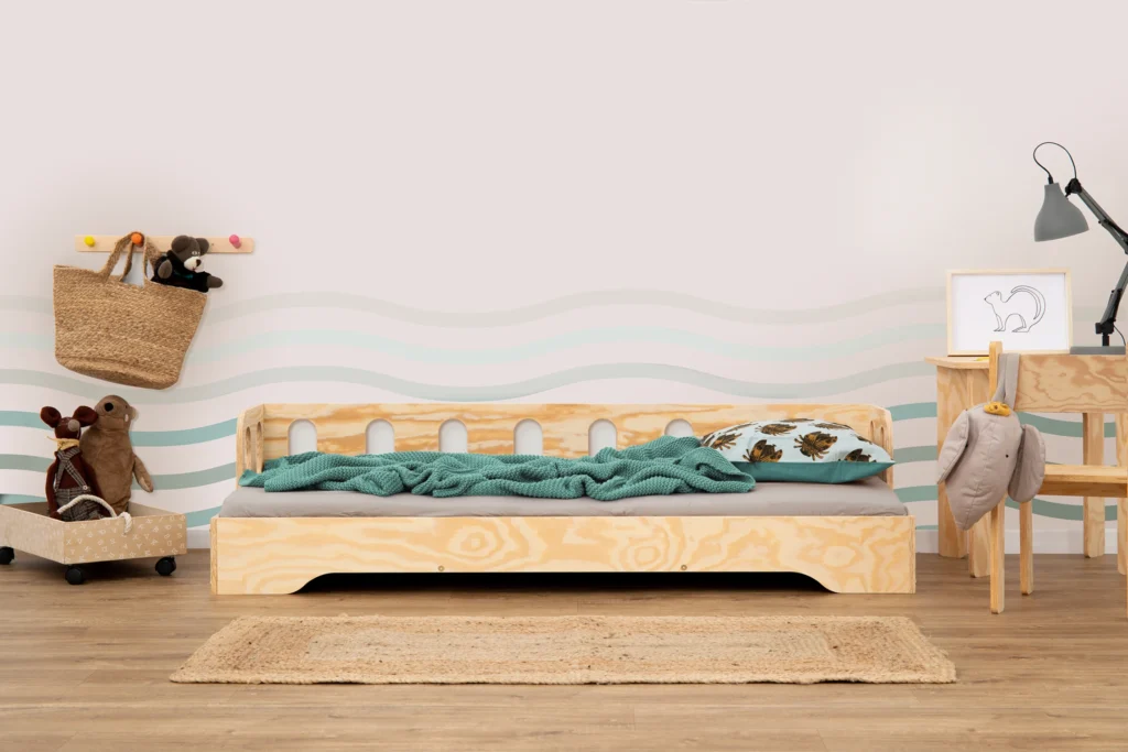 Lit en bois fabriqué en contreplaqué de pin couleur bois naturel avec une barrière à ouvertures ovales