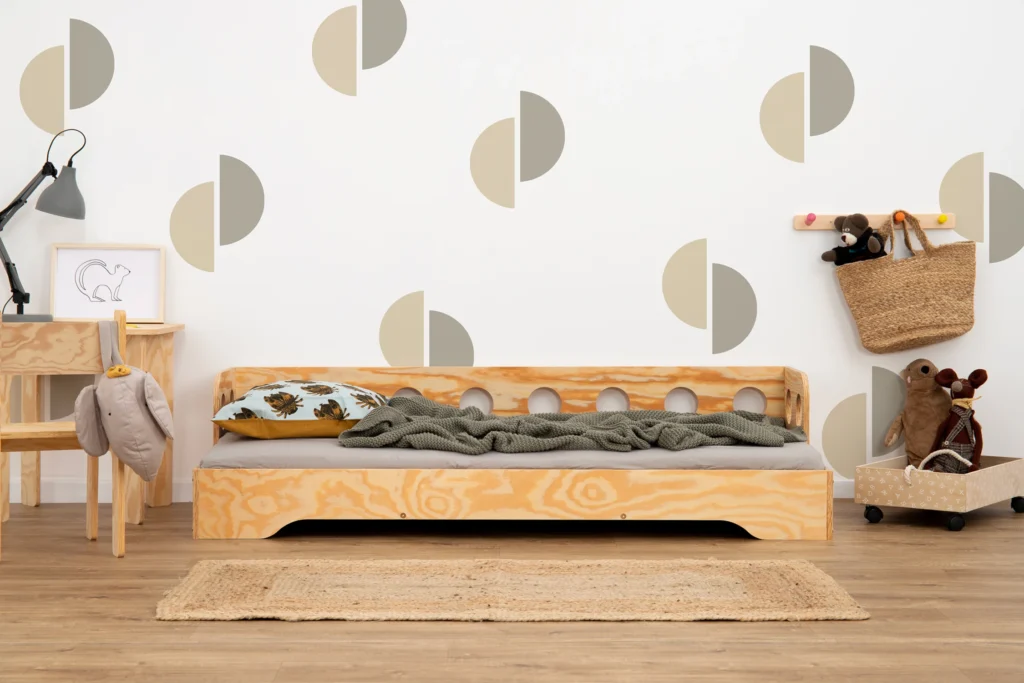 Lit en bois fabriqué en contreplaqué de pin couleur bois verni avec une barrière à ouvertures rondes