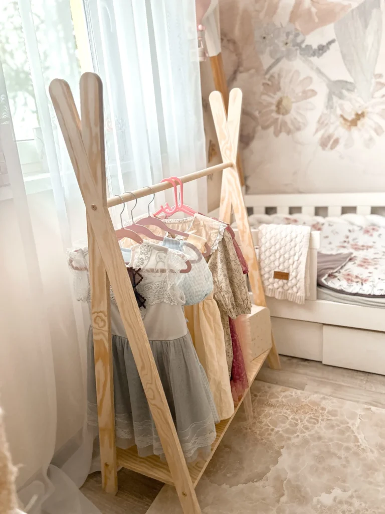 Porte-manteau en bois en forme de tipi avec des vêtements pour enfants suspendus