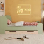Letto per bambini in legno realizzato in compensato di pino di colore verde con testiera alta e cassetto.