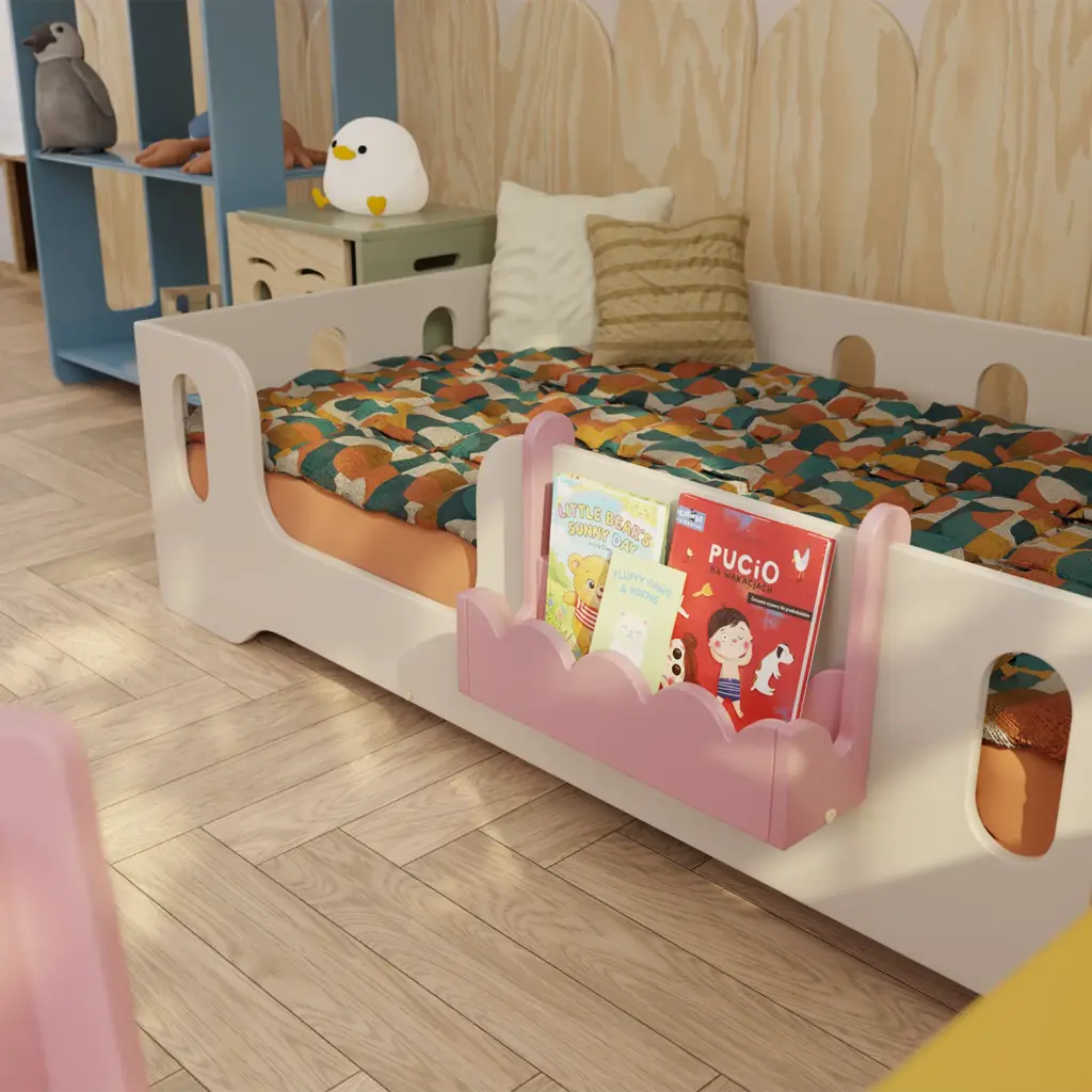 Mensola sospesa rosa in legno per libri per bambini LULI Montessori, montata accanto al letto.
