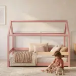 Letto a casetta MILO color rosa con struttura a capanna, un bambino gioca con i cubi di legno accanto al letto.