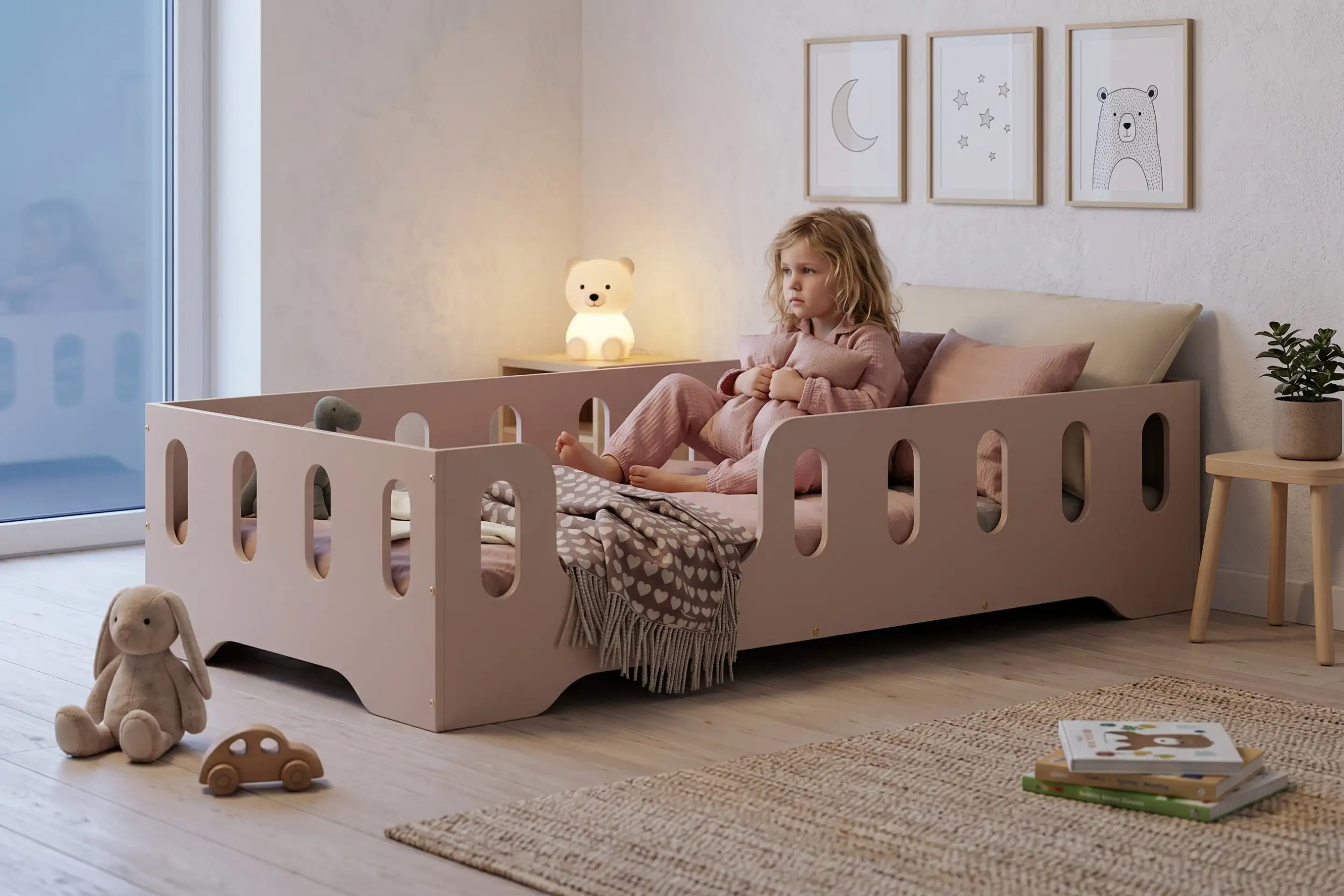 Letto per bambini TILA 2 color cachemire con sponde, bambina seduta che abbraccia un cuscino in una cameretta calma e accogliente.