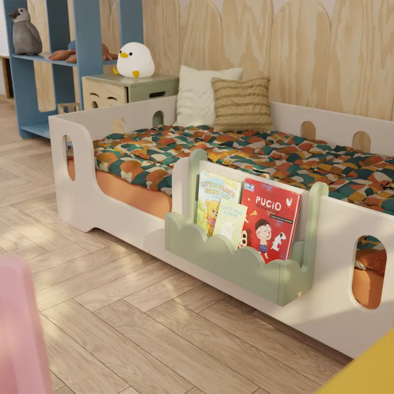 Mensola sospesa Luli verde per libri, montata sul lato del letto per bambini.