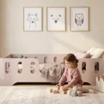 Lettino per bambini TILA 2 color cashmere con sponde, bambina che gioca con cubi di legno sul tappeto accanto al letto.